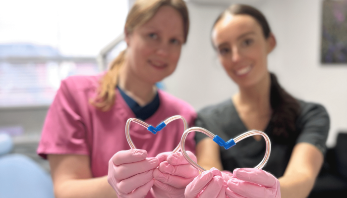 Dental team holding up heart shapes for Valentine's Day